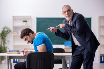 Old male teacher and young phone addicted student in the classro