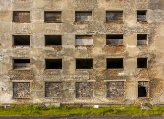 Fototapeta na wymiar Windows without glass in an abandoned brick house.