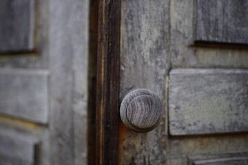 Old brown shabby wooden door with a round knob.