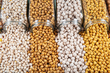 different types of chickpeas in glass jars,white chickpeas,coated chickpeas,sugar coated chickpeas,salty chickpeas.