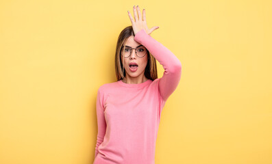 pretty caucasian woman raising palm to forehead thinking oops, after making a stupid mistake or...