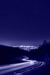 Foto auf Acrylglas Pantone 2022 very peri Sternenhimmel über den Lichtern der Stadt und Lichtspuren. Nachtfotografie, getönt in trendiger Farbe des Jahres 2022 Very Peri