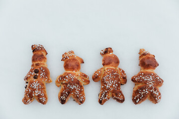 Homemade dough men on snow made with sweet yeast dough and covered with decorative sugar. Swiss...