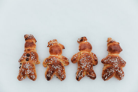 Homemade dough men on snow made with sweet yeast dough and covered with decorative sugar. Swiss tradition to bake dough men  - called in German Grittib&auml;nzli - on December 6 and in Advent time.