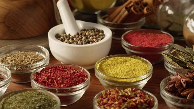 Various spices in glass bowls close-up. Middle eastern and arabian culture. Seasoning and flavors. Pepper, coriander, cinnamon, turmeric, paprika, cumin. Different kinds of dry herbs for cooking. 