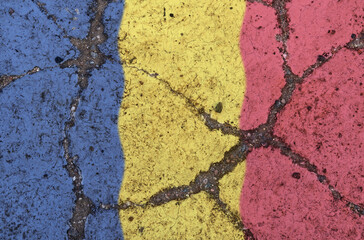 Romania flag on cracked asphalt. The concept of crisis, default, pandemic, conflict, terrorism. Out of focus image