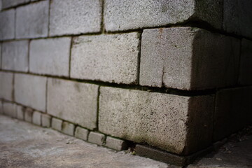 Grey cinder block wall with wet seams. Perspective close up view.