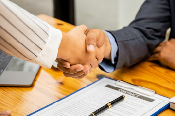 Business negotiations, image of a business man holding a business woman's hand, two happy with his work, they enjoy his colleagues, people gesture handshake concept.