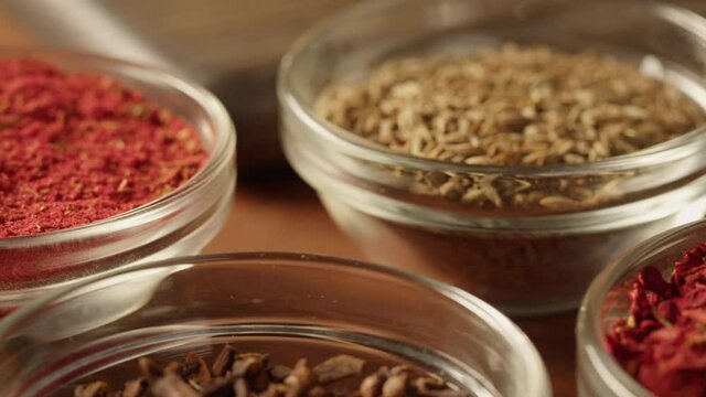 Spices in glass bowls close-up. Middle eastern and arabian culture. Seasoning and flavors. Pepper, coriander, vanilla, turmeric, paprika, cumin. Different kinds of dry herbs for cooking. 