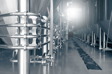 Modern brewery production steel tanks and pipes, machinery tools and vats, beer production. Family business concept.
