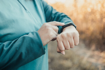 Active sport woman setting up the fitness smart watch for timing running workout.