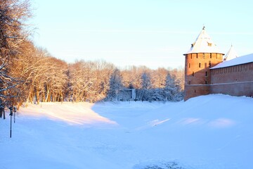 Sunny day in winter park, old castle on the hill covered by snow