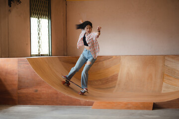 Asian women surf skate or skates board indoor beautiful summer day. Sport activity lifestyle concept