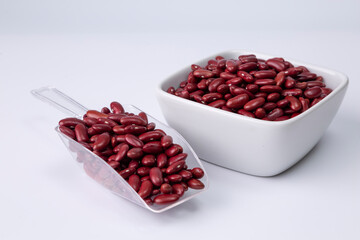 red kidney bean in white bowl and plastic spoon on background studio shot