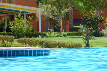 Blue clear water with small ripple waves in swimming pool at tropical resort. Summer vacations concept