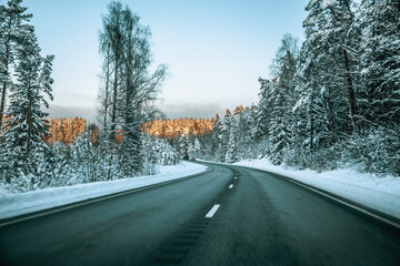 Fototapeta na wymiar Winter asphalt road. Winter road and trees with snow and Latvian landscape. Soft focus on photos.