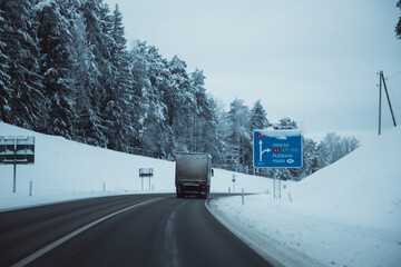 Winter asphalt road.  Winter road and trees with snow and Latvian landscape. Soft focus on photos.