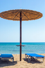 Two sun beds under sun umbrella at the beach. Zephyros beach. Gr