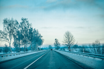 Obraz premium Winter asphalt road. Winter road and trees with snow and Latvian landscape. Soft focus on photos.