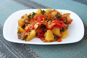 meat stew with vegetables on a white dish