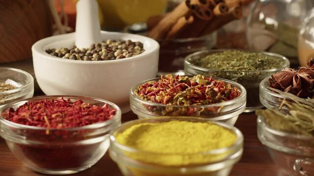 Colourful spices in glass bowls close-up. Middle eastern and arabian culture. Seasoning and flavors. Pepper, coriander, cinnamon, turmeric, paprika, cumin. Different kinds of dry herbs for cooking. 