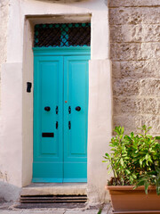 Fototapeta na wymiar Narrow vintage door of turquoise colour downtown Valetta, Malta