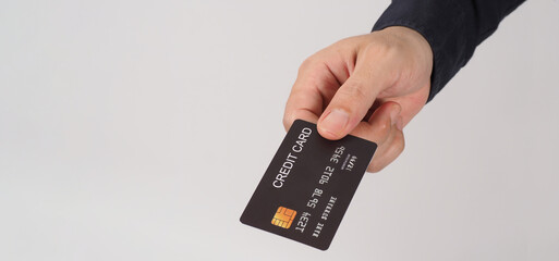 Hand is holding black credit card isolated on white background. Asian man hand..