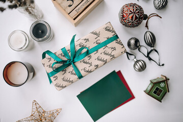 Beautiful Christmas present on a white table with decorations and a blank card