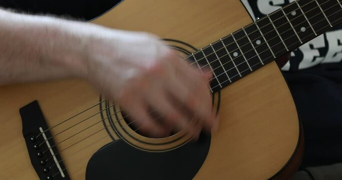 Mans hands playing acoustic guitar, playing. Music concept