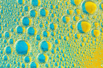 Psychedelic blueand yellow oil and water abstract background. Abstract colorful background. Foam of Soap with Bubbles macro shot. Closeup bubbles in water