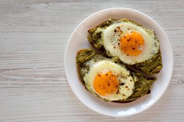 Homemade Pesto Egg Toast on a white plate, top view. Flat lay, overhead, from above. Copy space.