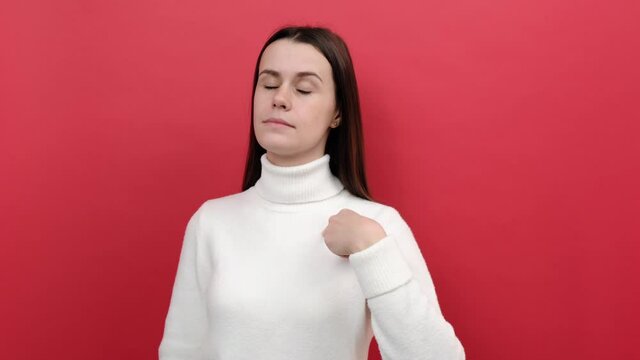 Portrait of confident young brunette woman 20s pointing finger on herself, bragging with achievements, wears white jumper, posing isolated over red color background wall in studio. Egoism concept