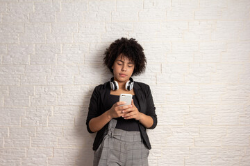 Confident african american girl with curly hair  looking at cell phone screen. Technology, social...