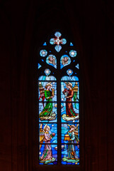 Antique religious stained glass window in an old gothic temple in Spain.