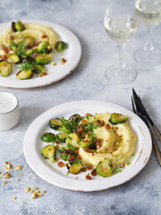 Brussels sprouts with pistachios, raisins and Skordalia (mashed potatoes). Healthy Meal preparation. Plant-based dishes. Green living. Vegan recipe. Food styling. Vegetarian cuisine