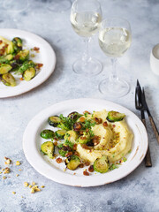 Brussels sprouts with pistachios, raisins and Skordalia (mashed potatoes). Healthy Meal preparation. Plant-based dishes. Green living. Vegan recipe. Food styling. Vegetarian cuisine