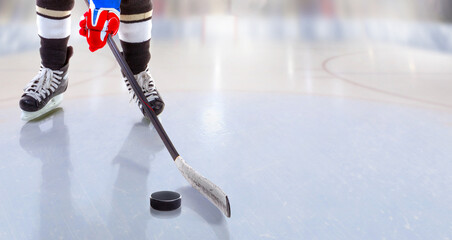 Close up of ice hockey player with stick on ice rink controlling puck - 474258991