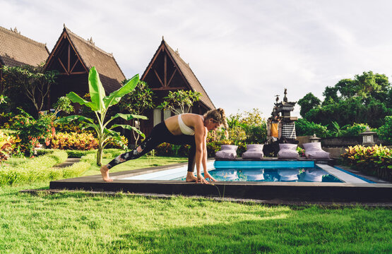 Strong woman doing yoga on poolside