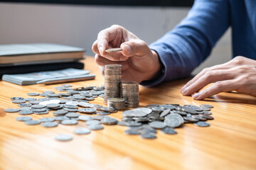 Young man and pile coins to planning growing saving strategy with pile coins for future plan fund...