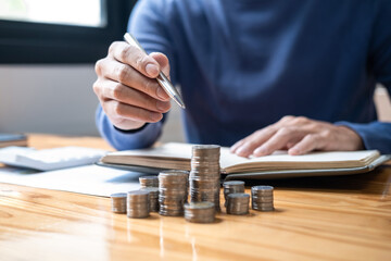 Young man and pile coins to planning growing saving strategy with pile coins for future plan fund...