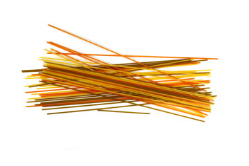 long multicolored pasta, flavoured spaghetti isolated on white background. Uncooked dry fettuccine pasta tied in a bundle isolated on a white background. Raw spaghetti. Beautiful raw spaghetti pasta.