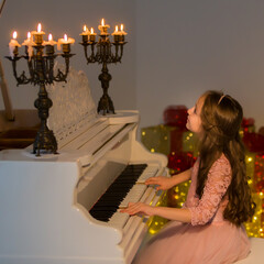 Beautiful Girl Playing Piano and Looking at Burning Candles