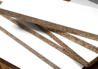 Pieces of white chipboard stacked. Material for the construction of furniture in the carpentry shop. Workplace workshop.