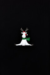 Christmas deer on a black, dark, night background in a red santa claus hat. New year minimalistic concept. Icon 
