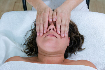 Fototapeta na wymiar Energetic massage on the eyes of woman