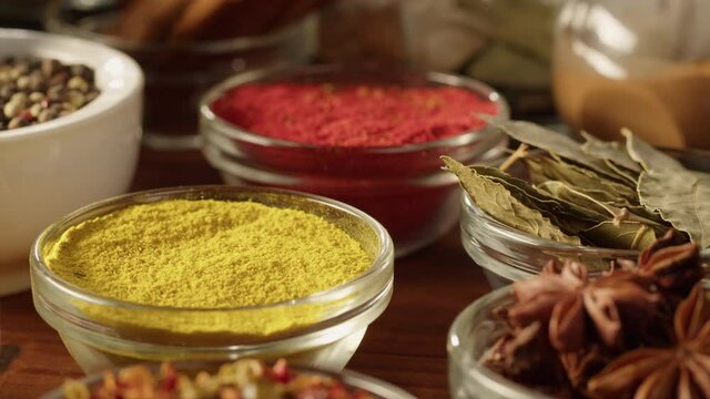 Various spices in glass bowls close-up. Middle eastern and arabian culture. Seasoning and flavors. Pepper, coriander, cinnamon, turmeric, paprika, bay leaf, star anise. Dry herbs for cooking. 