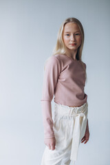 Portrait of blondie young caucasian girl in studio. Fashionable portrait of pretty teen girl
