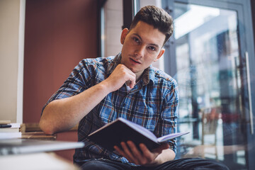 Portrait of contemplative male student dressed in smart casual clothes thoughtful looking at camera...