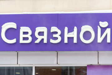 A sign on the store building with an inscription in Russian: Svyaznoy