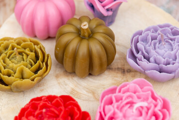 Homemade candles in different colors and shapes. Candles in the form of flowers and fruits. Gifts for the holiday.